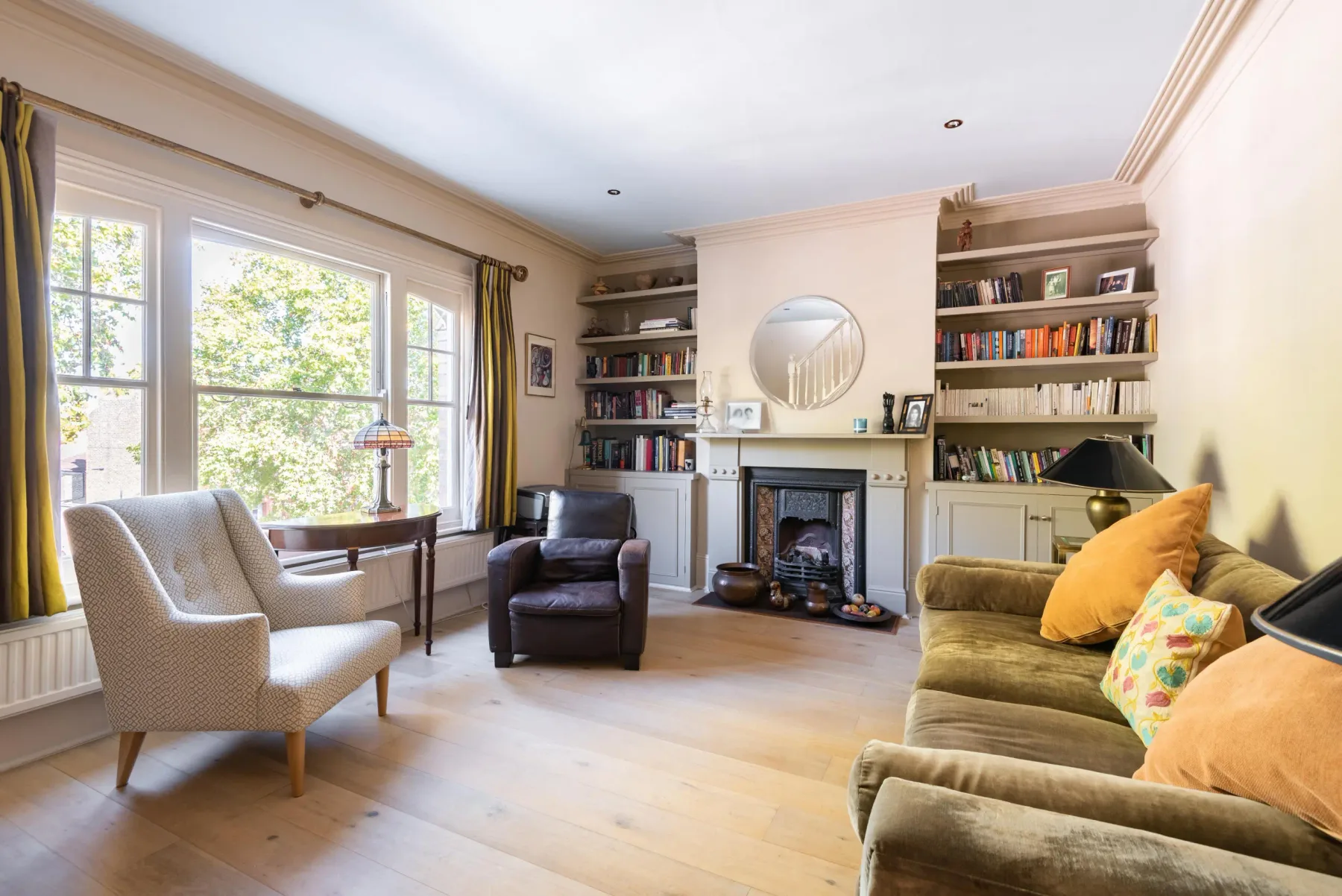 Living room with bookshelves, seating, and a fireplace.
