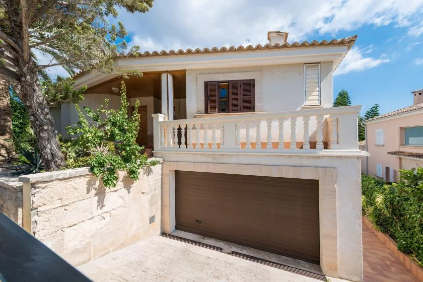 A house exterior with a balcony above a garage door.