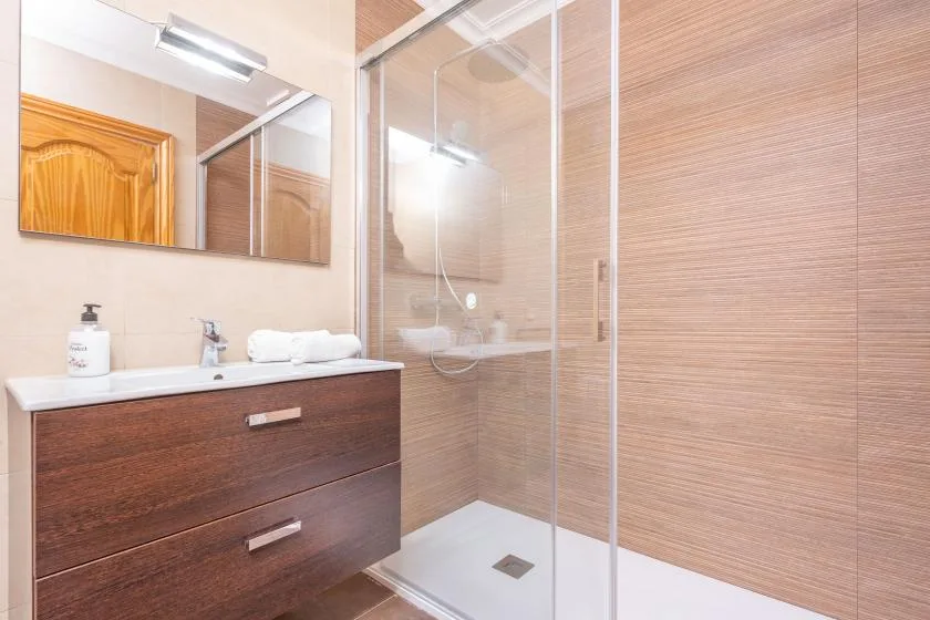 A bathroom with a vanity beside a glass shower.