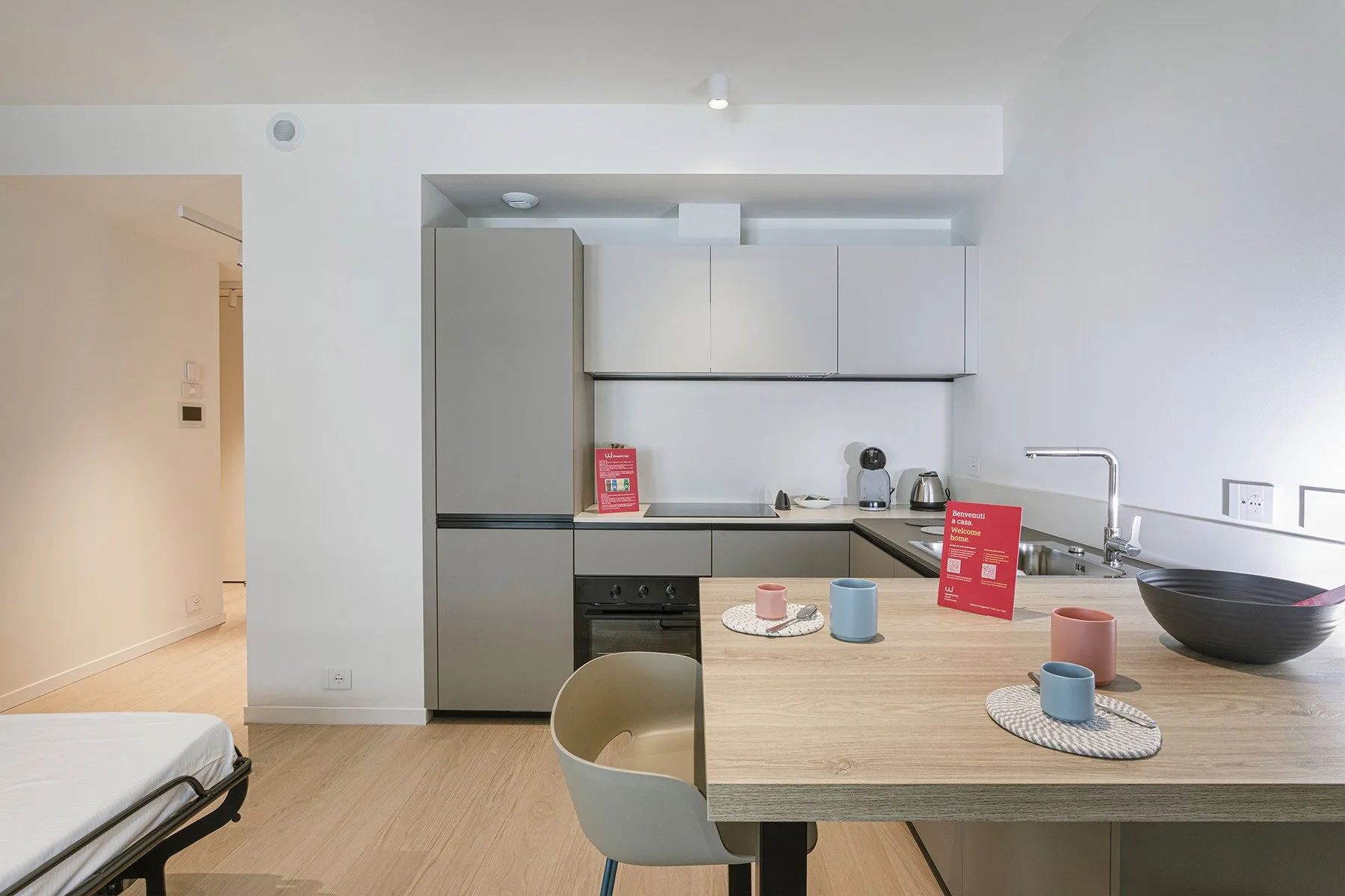 A bright kitchen with a refrigerator, countertop appliances, and a dining table.