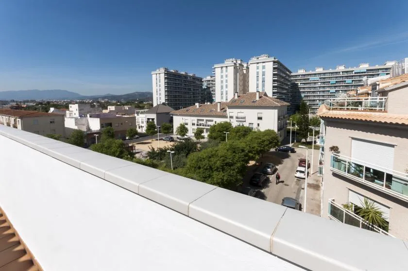Una vista elevada muestra un barrio residencial con árboles y edificios de apartamentos.