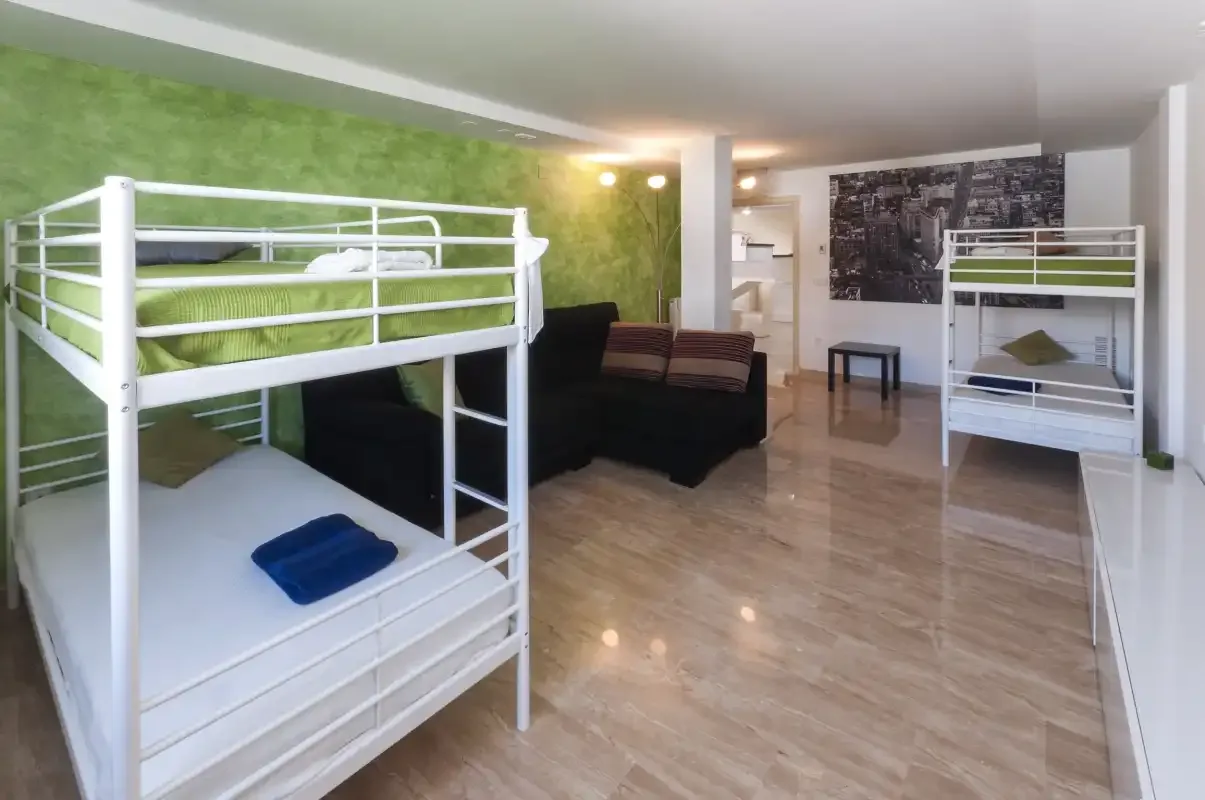 Una habitación con literas y una zona de estar.