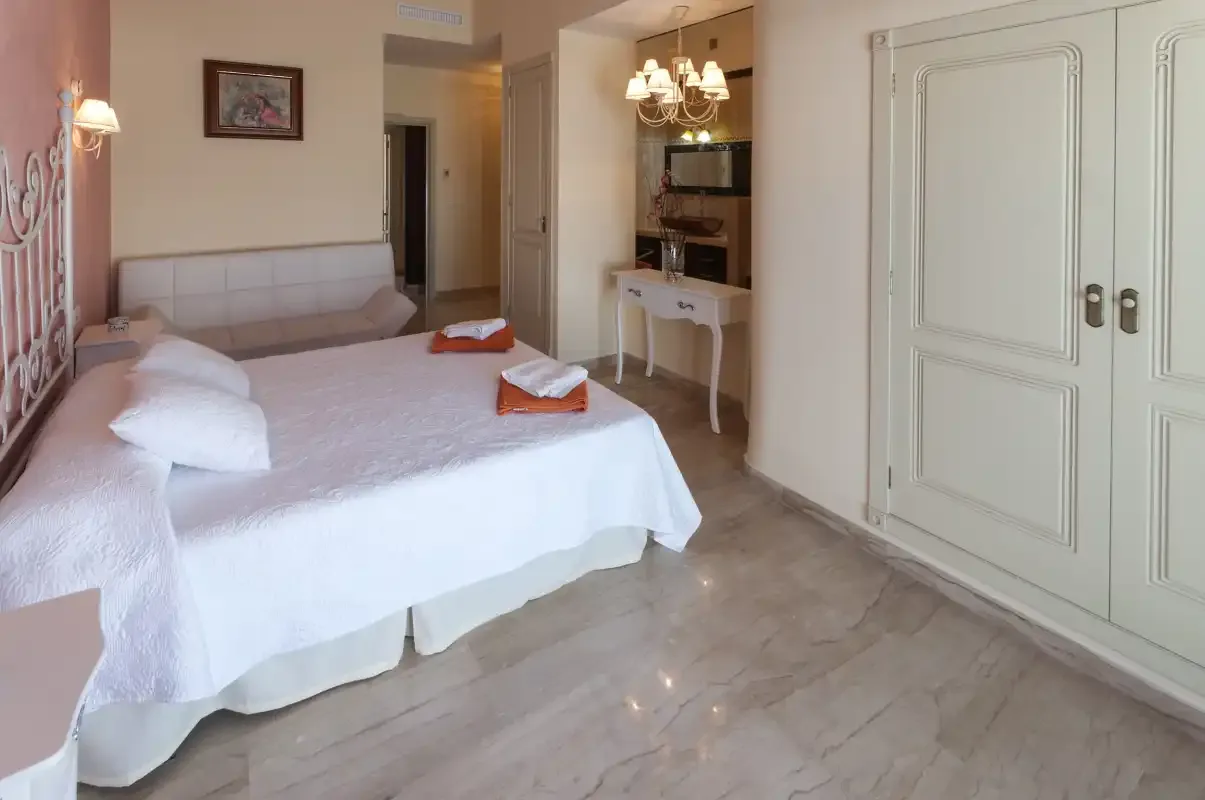 Dormitorio con una cama, una zona de estar y armarios empotrados.