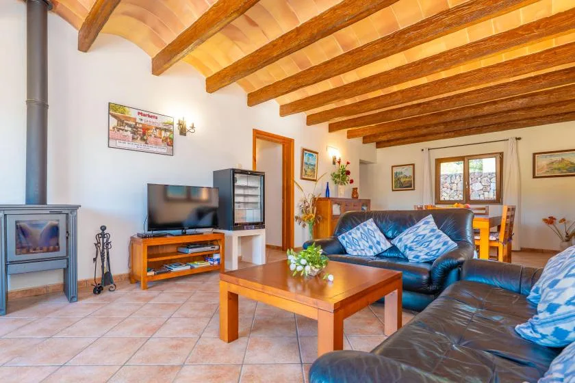 A living room with seating, a wooden coffee table, and exposed ceiling beams.