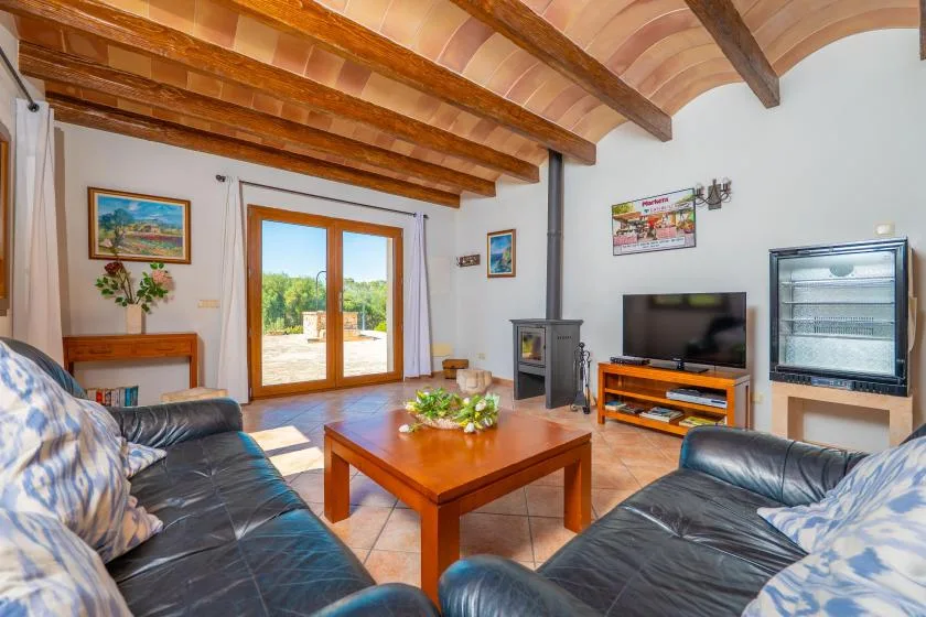 A living room with seating, a television, and a wooden coffee table.