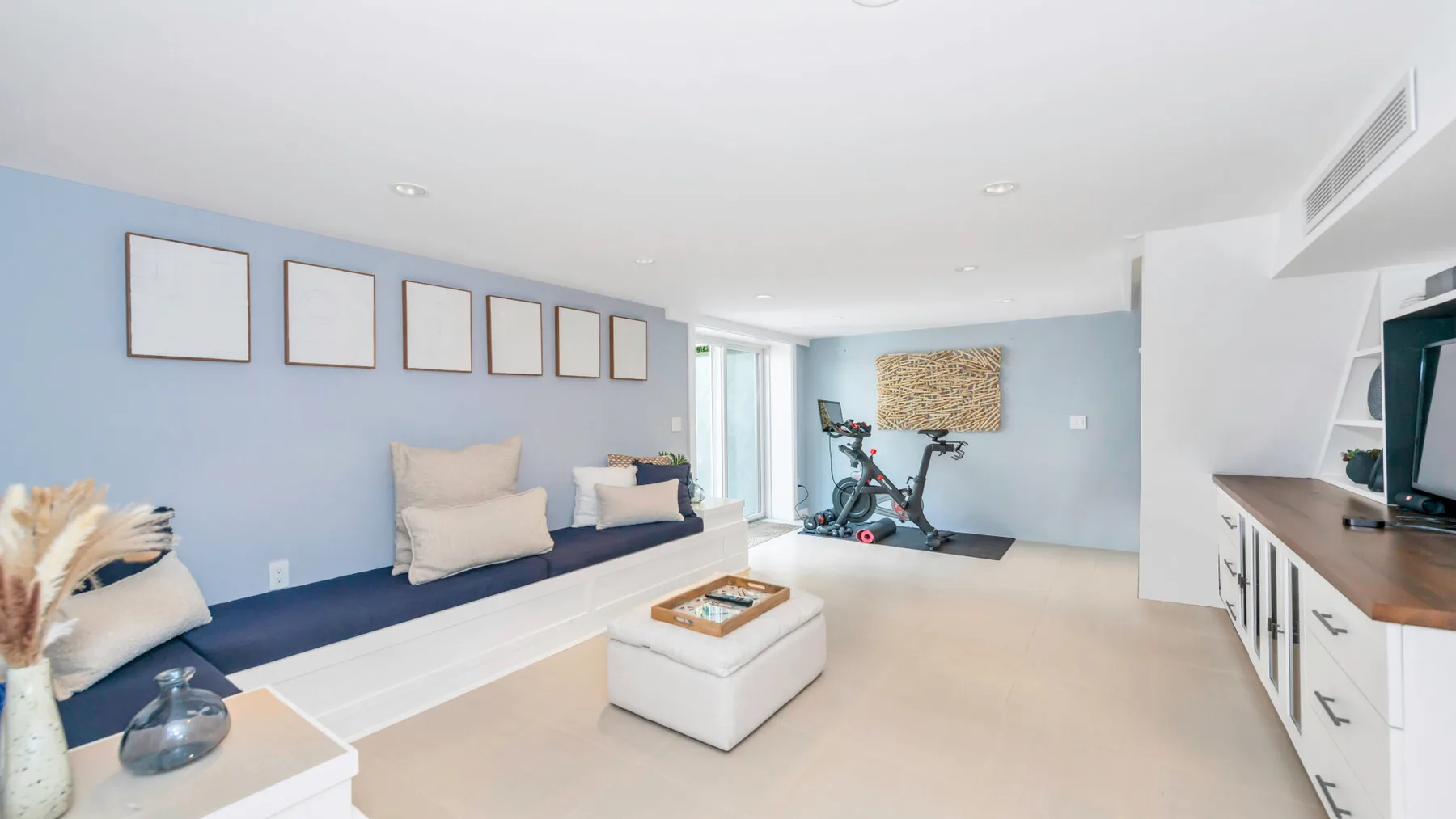 A bright living area with built-in seating and an exercise bike.