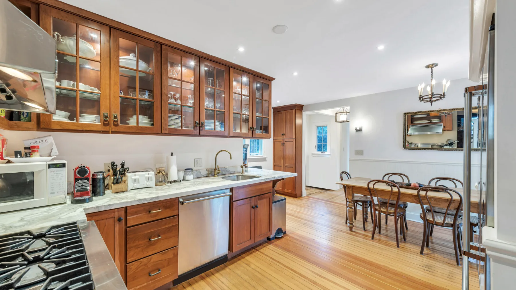 Una cocina y comedor con gabinetes de madera y una mesa.