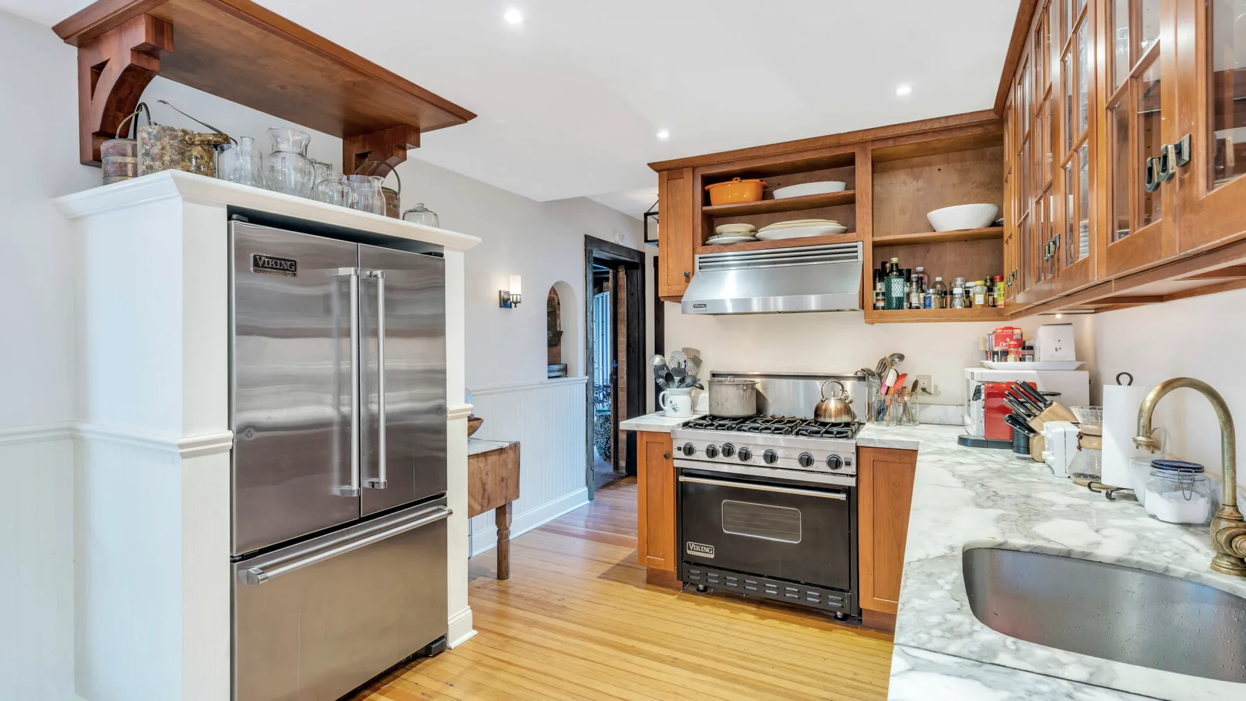 Una cocina con electrodomésticos de acero inoxidable y gabinetes de madera.