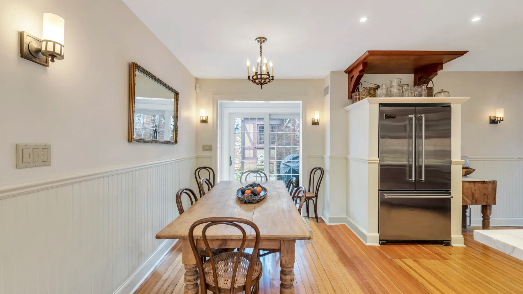 Un comedor con una mesa larga de madera junto a una cocina.
