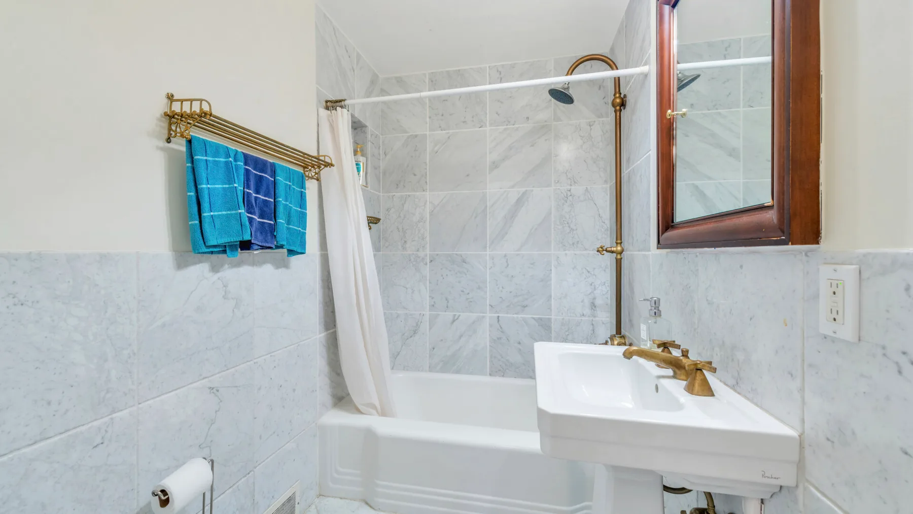 Un baño alicatado con bañera, cortina de ducha y lavabo.