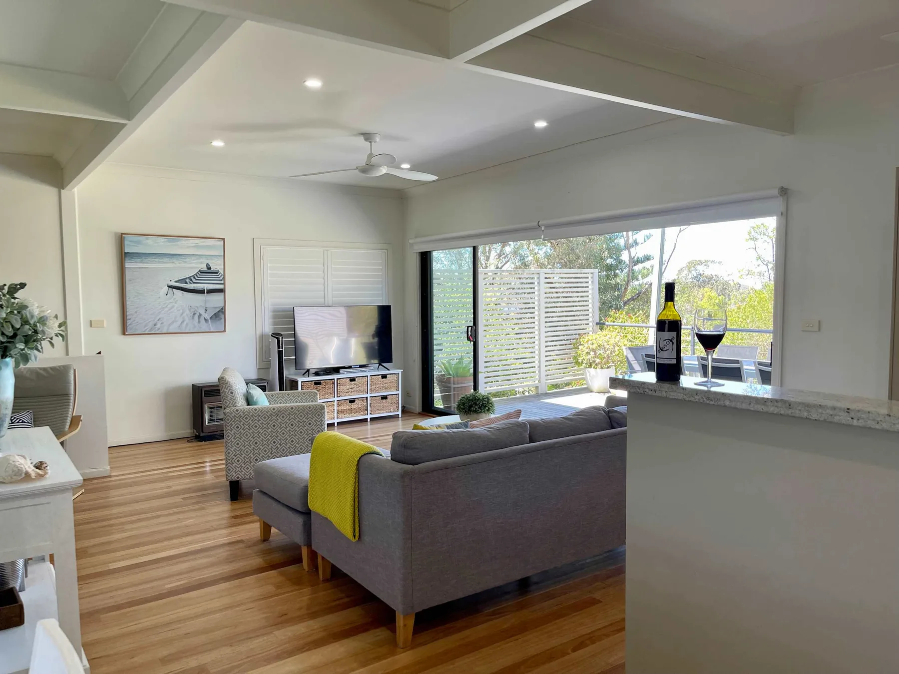A bright living room opens onto a patio through wide glass doors.