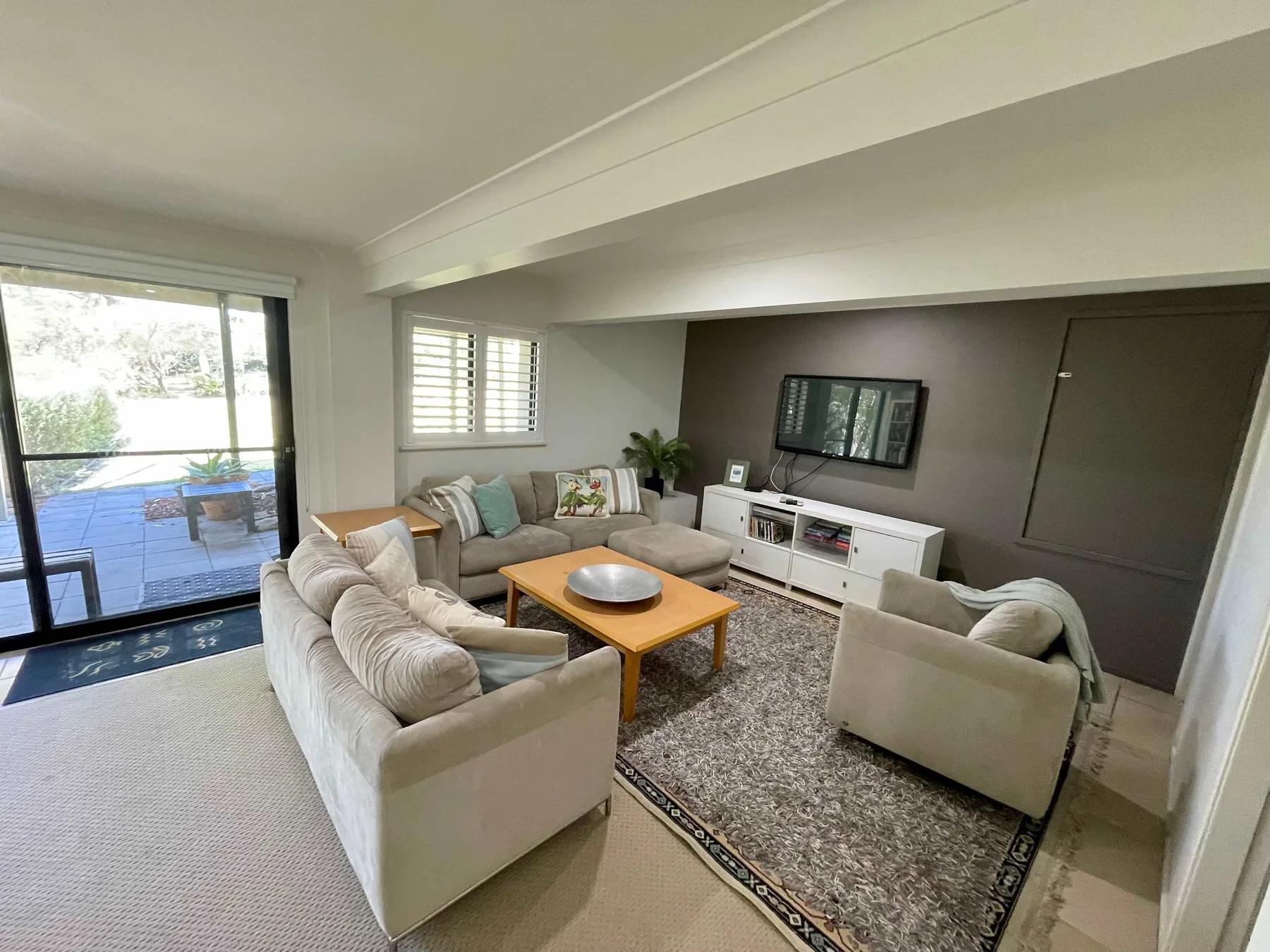 A living room with seating arranged around a coffee table and television.