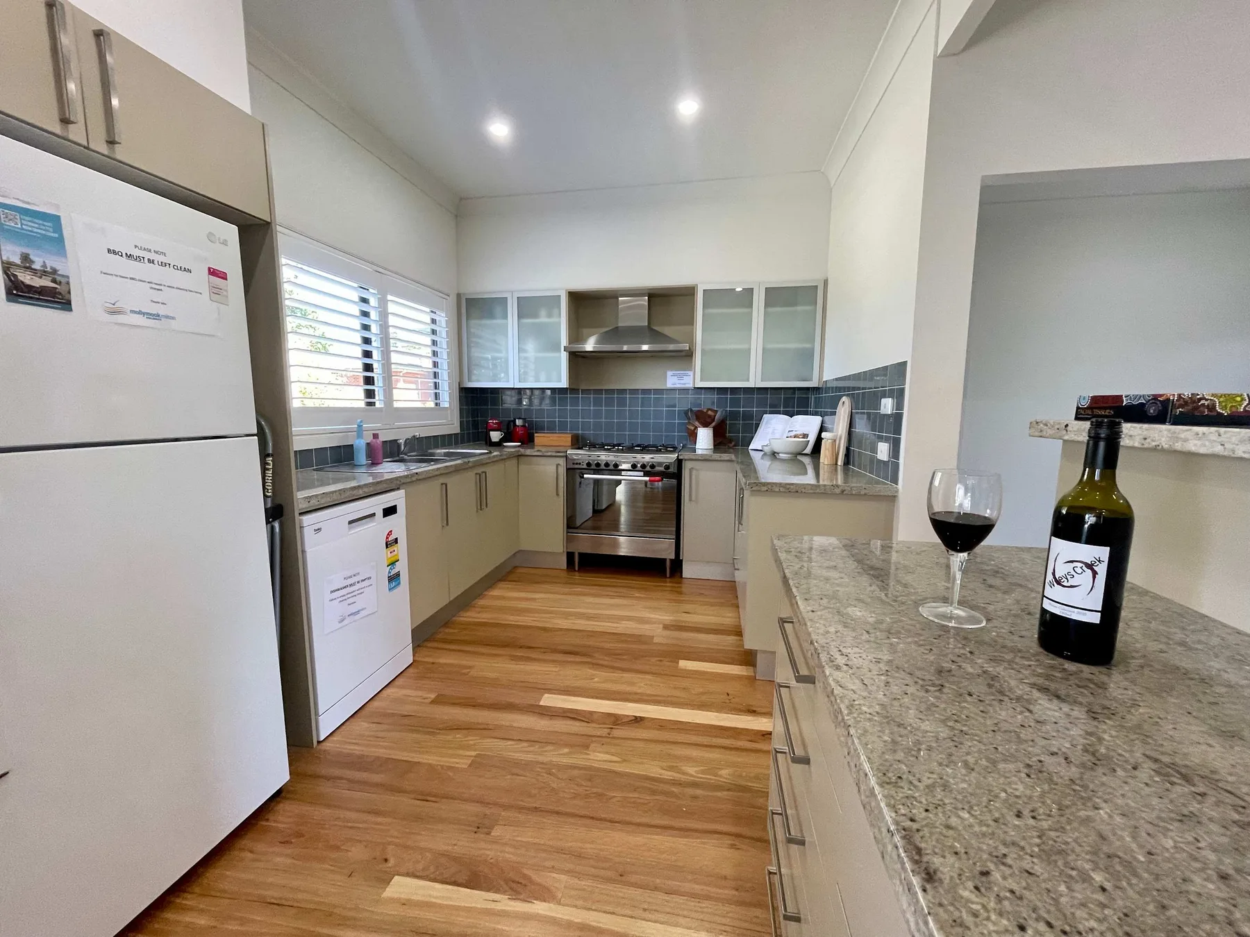 A bright kitchen with a central cooking area and stone counter.