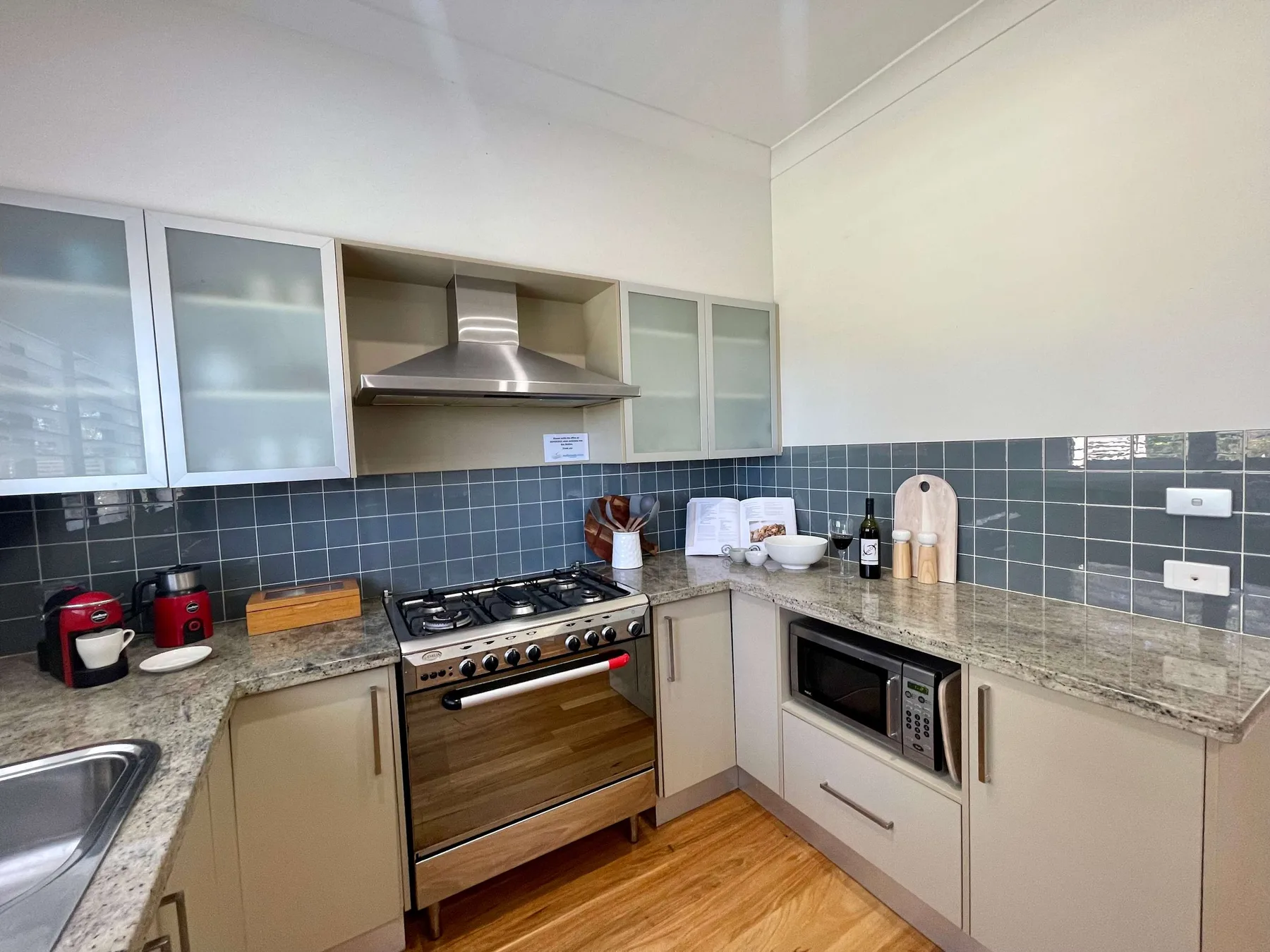 A kitchen with a gas cooktop, oven, and countertop appliances.