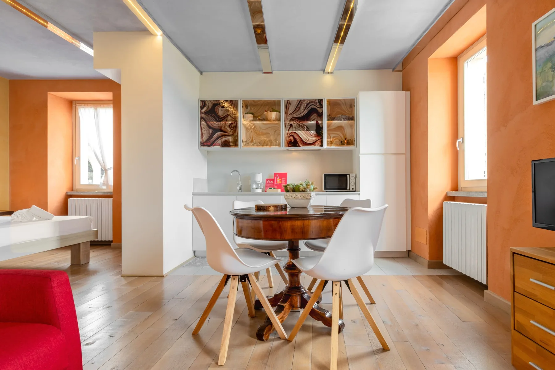 A dining area with a round table and chairs beside a compact kitchen.