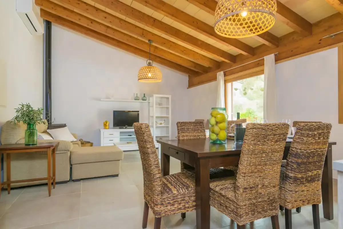 Una sala de estar y comedor con un televisor y sillas de comedor tejidas.