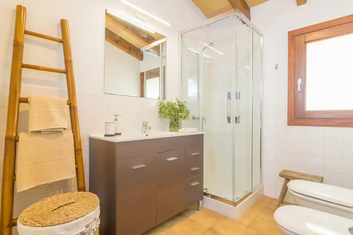 Un baño luminoso con lavabo, ducha de vidrio y ventana.