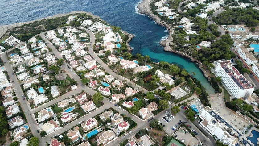 Aerial view of a coastal neighborhood beside a narrow inlet.