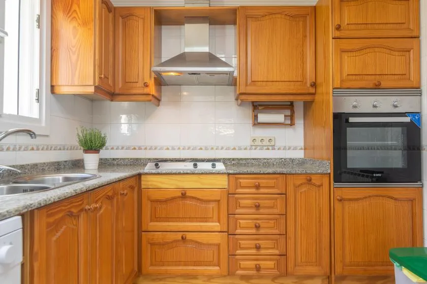 A kitchen with wooden cabinets, a countertop, and built-in appliances.