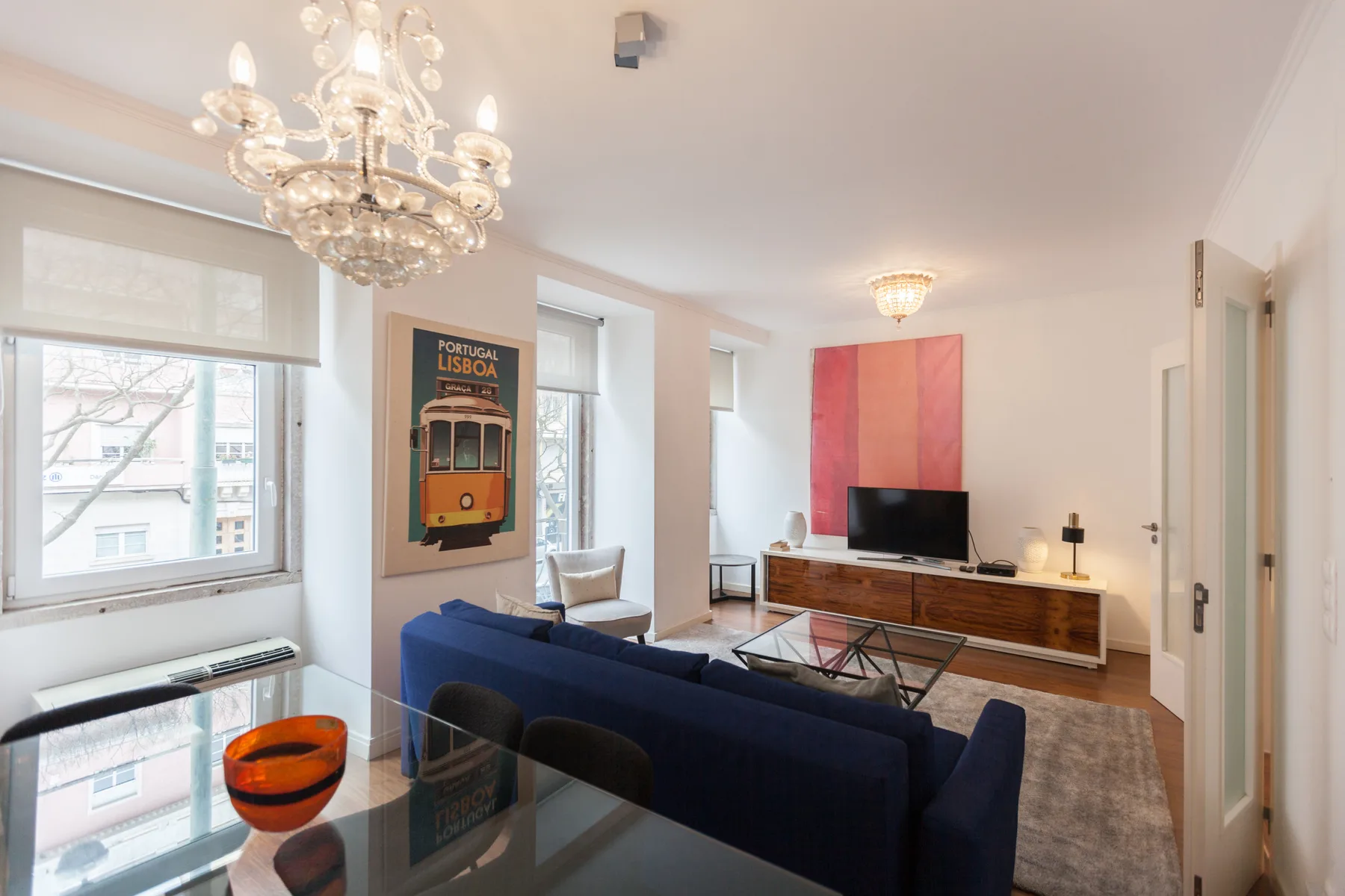 Living room with blue seating, a coffee table, and a television.