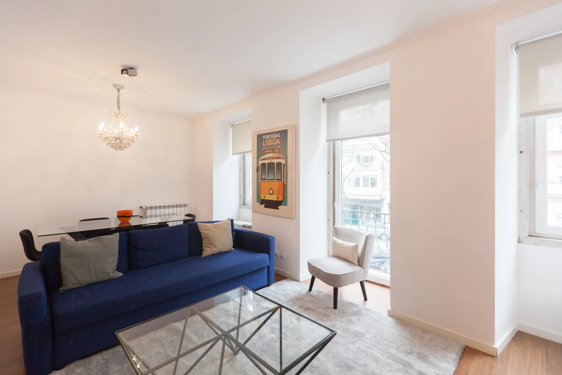 A bright living room with blue seating and large windows.