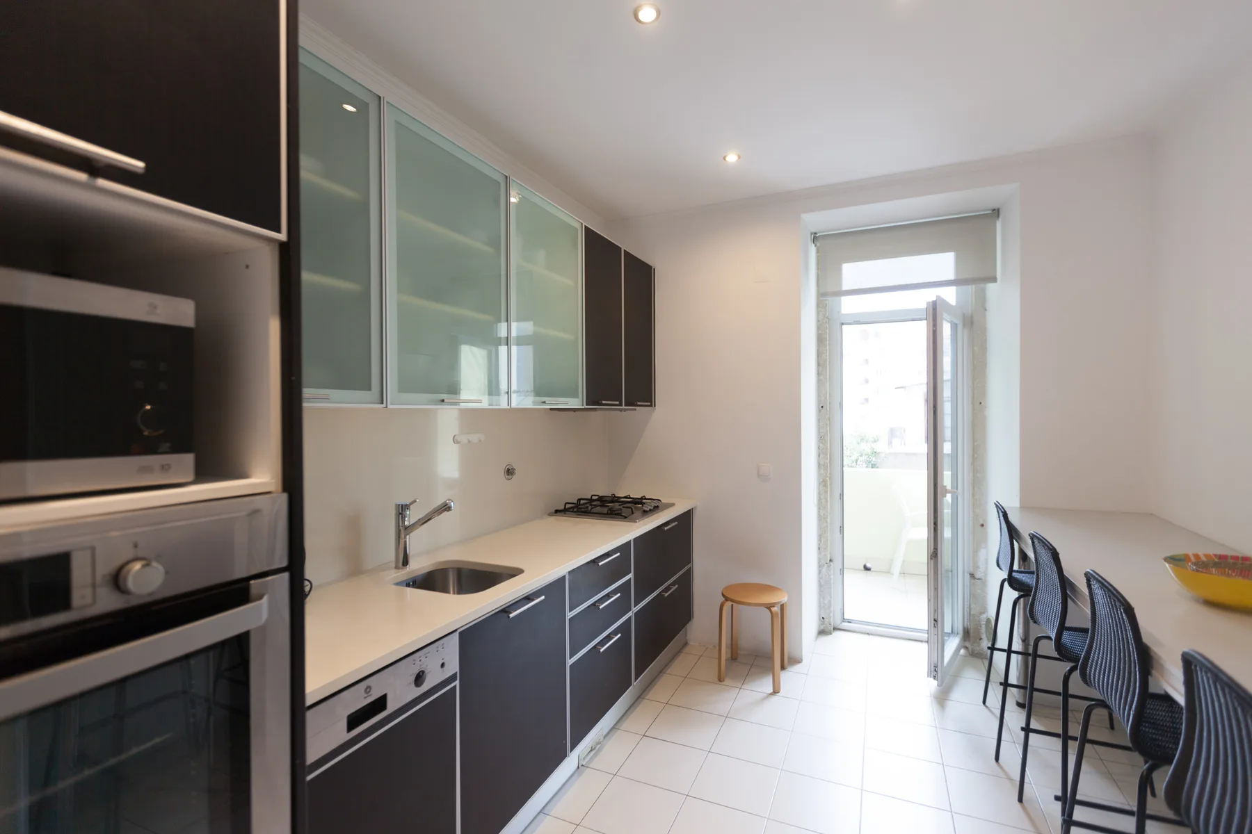 A kitchen with a countertop, cooking appliances, and a small dining area.