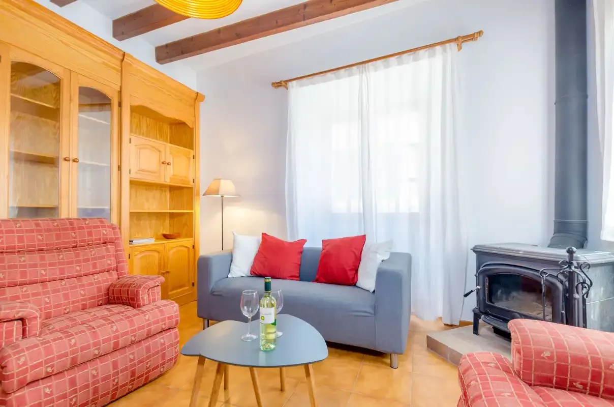 A living room with seating, a wooden cabinet, and a stove.