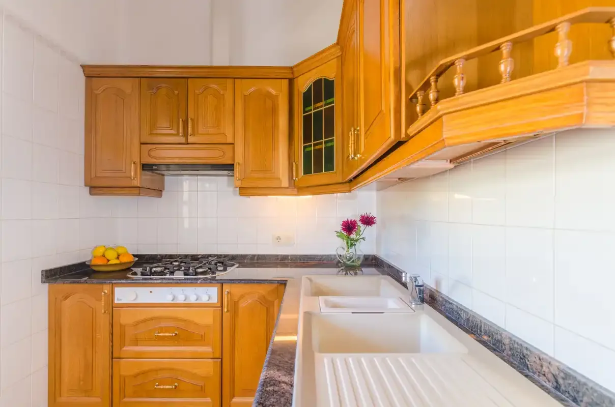 A kitchen with wooden cabinets, a countertop, and a sink.