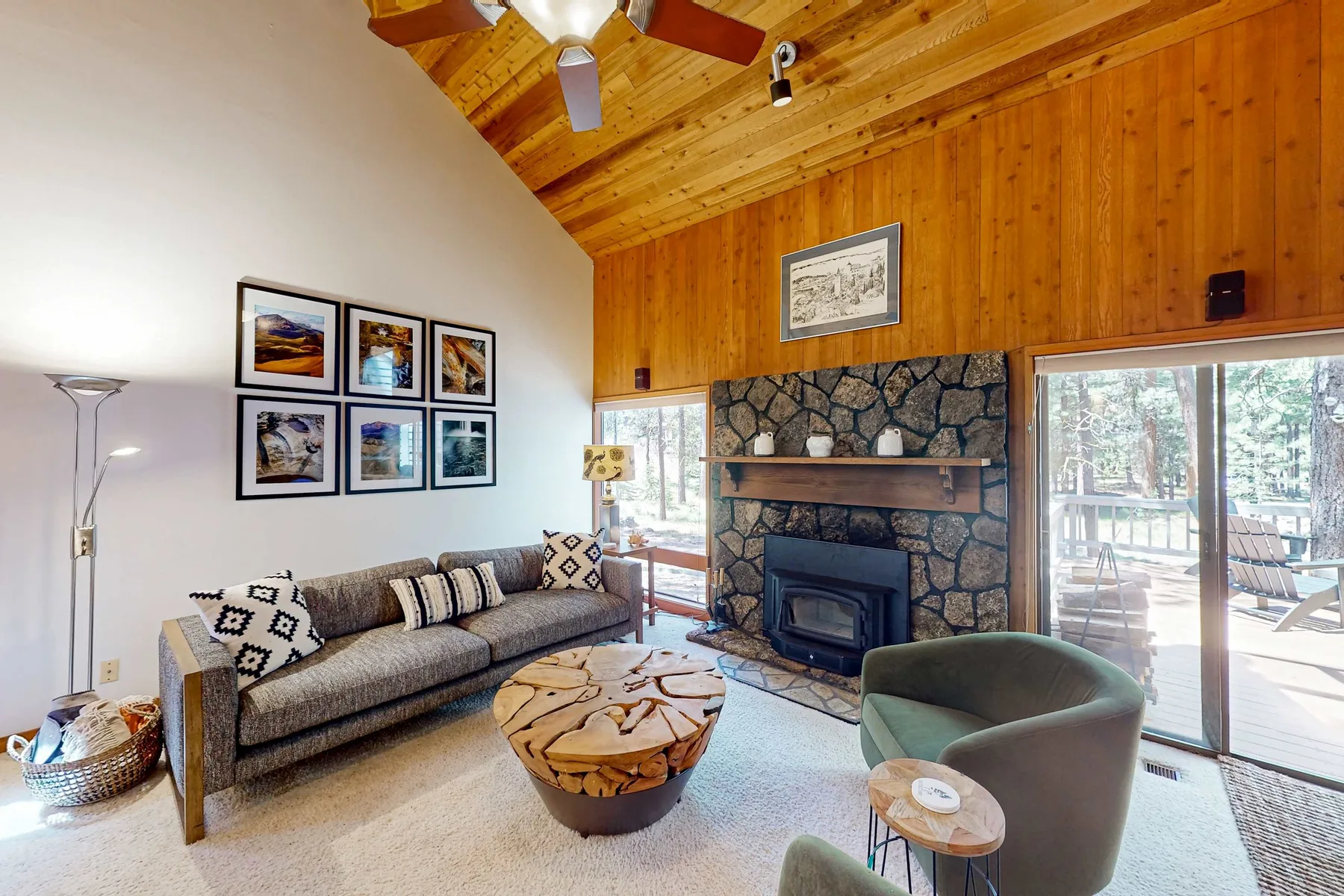 A living room with seating arranged around a stone fireplace.
