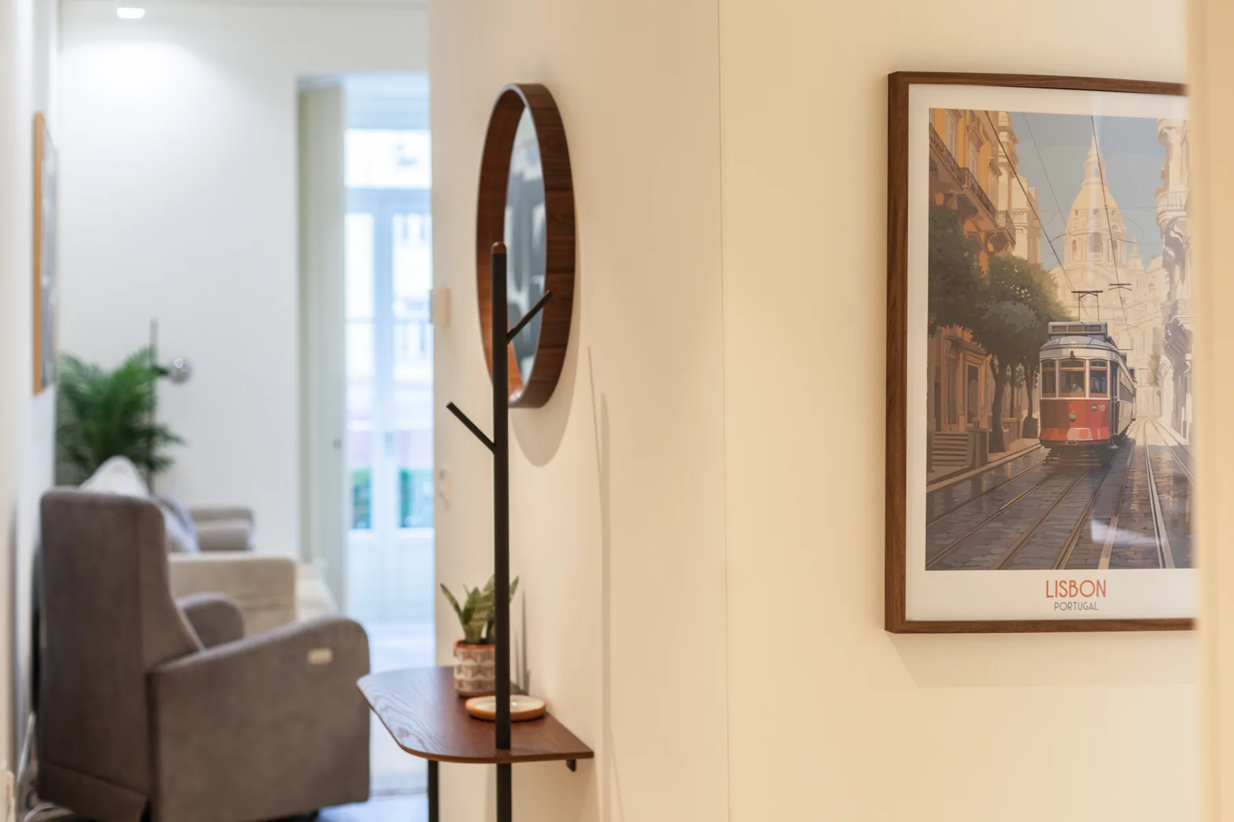 A living room with seating, a narrow console table, and framed wall art.