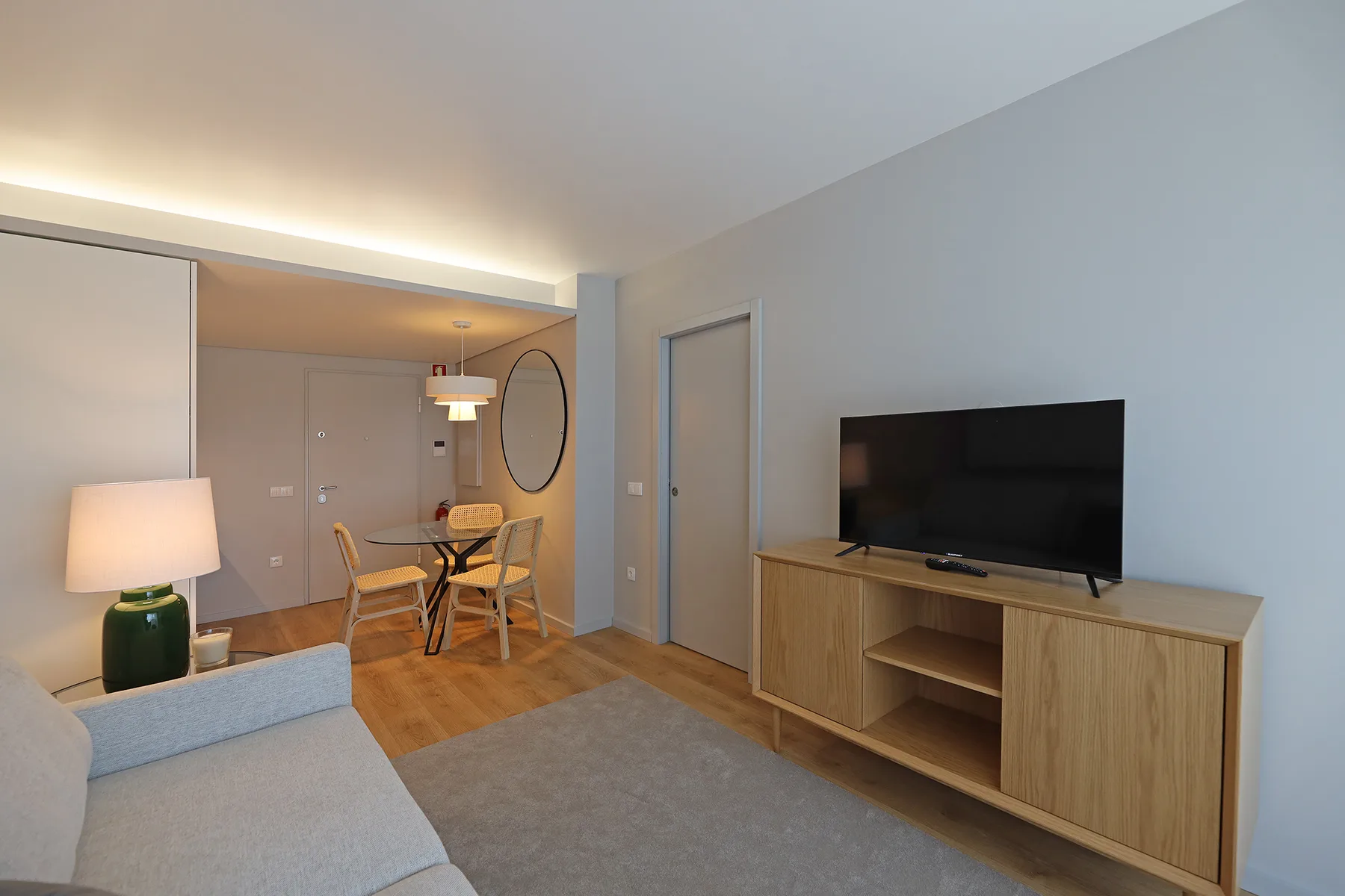 Una sala de estar con asientos, un televisor y una mesa de comedor.
