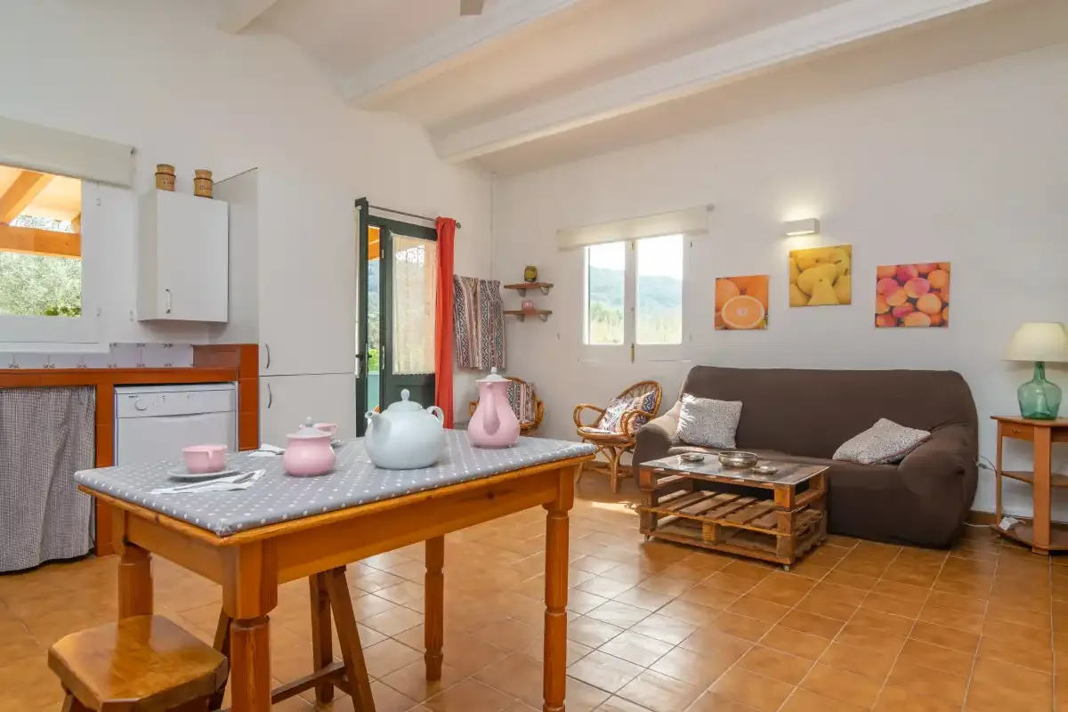 A bright living and dining area with a table, seating, and windows.