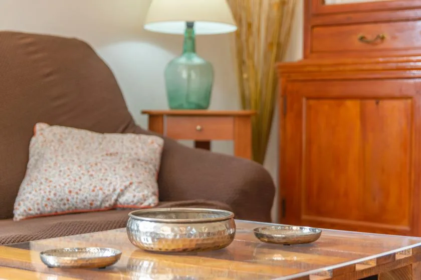 A living room seating area with a lamp and wooden cabinet.