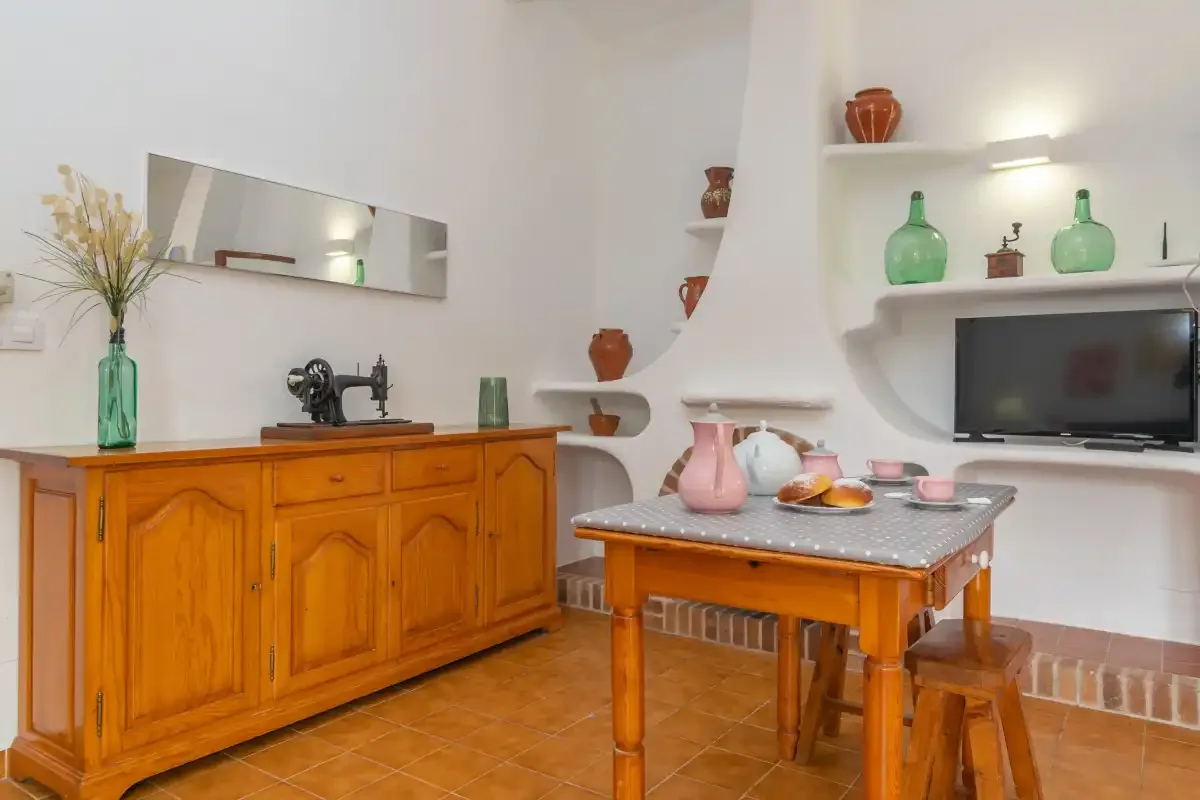 A dining area with a wooden sideboard, a table, and built-in shelves.
