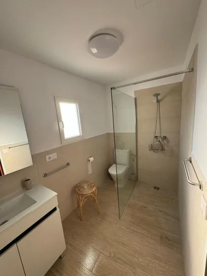 A bathroom with a sink, toilet, and glass shower area.