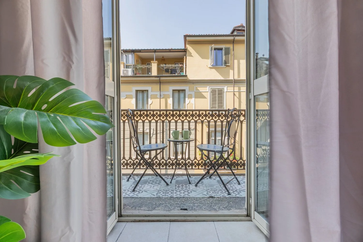 An open balcony with metal seating overlooks a neighboring building.