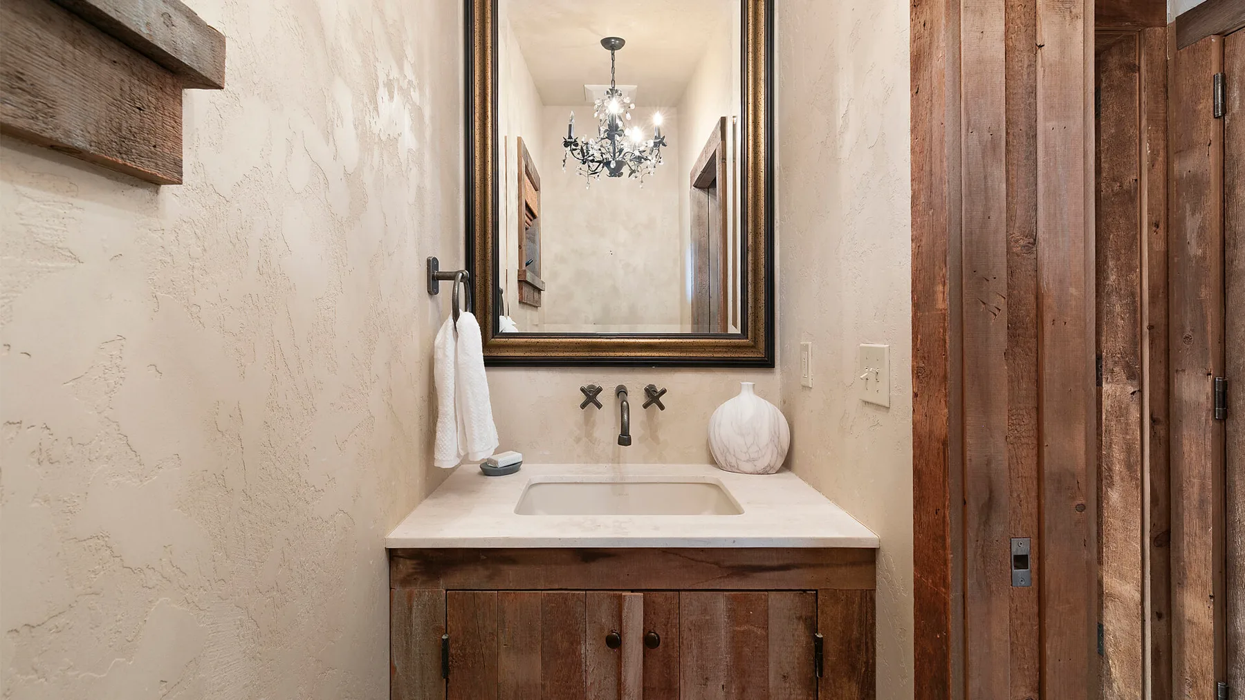 Un tocador de baño con lavabo, espejo y armarios de madera.
