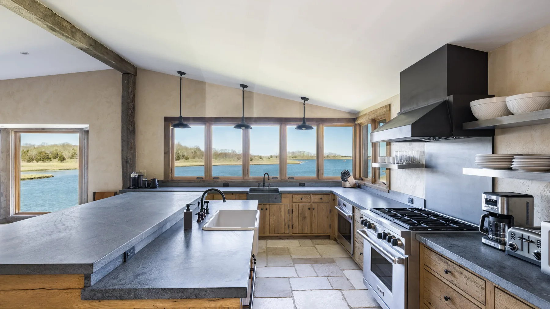 Una cocina amplia con una isla central y amplias ventanas con vistas al agua.