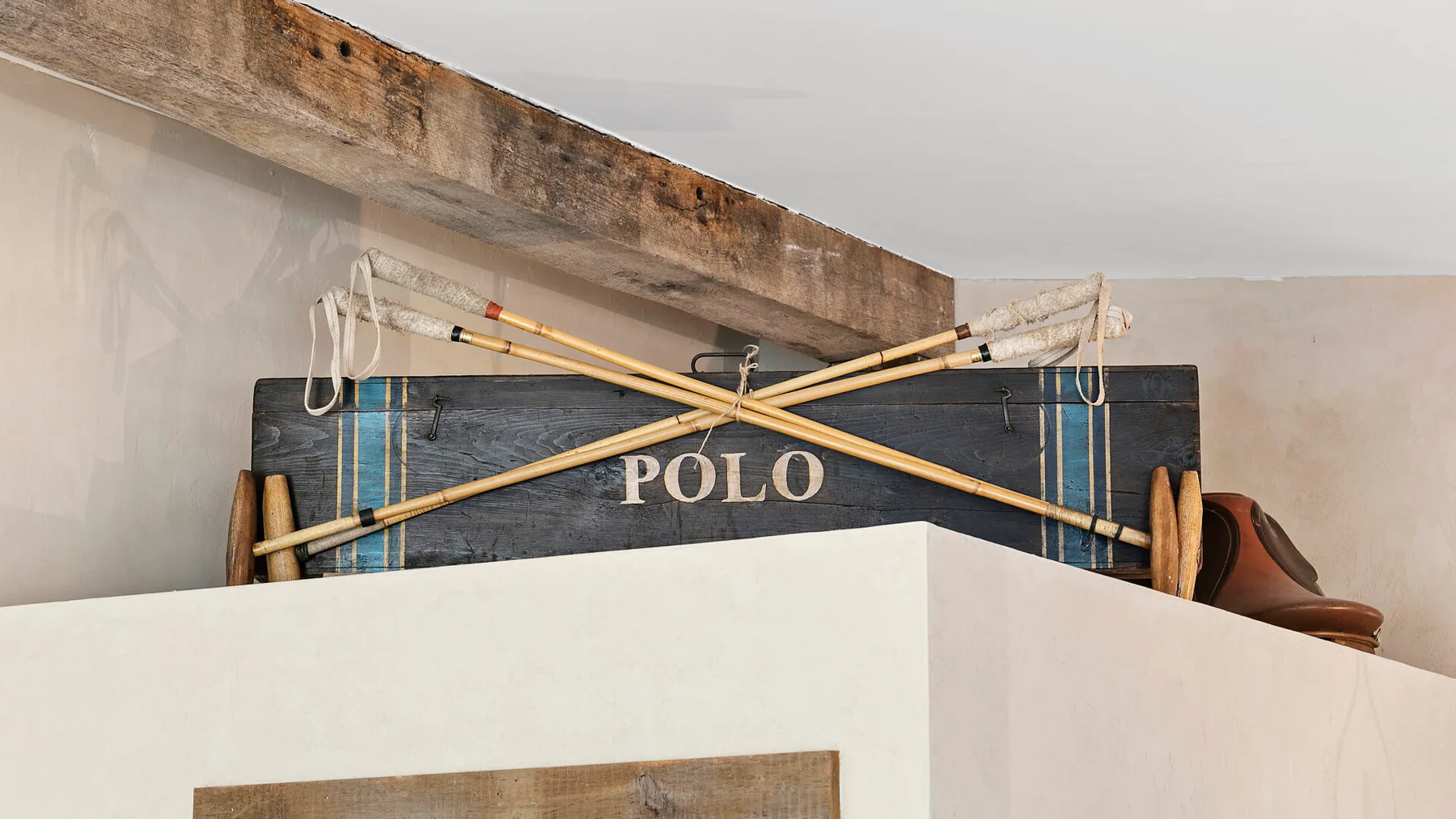 Interior de una habitación con un letrero de polo oscuro y mazos cruzados sobre un separador.