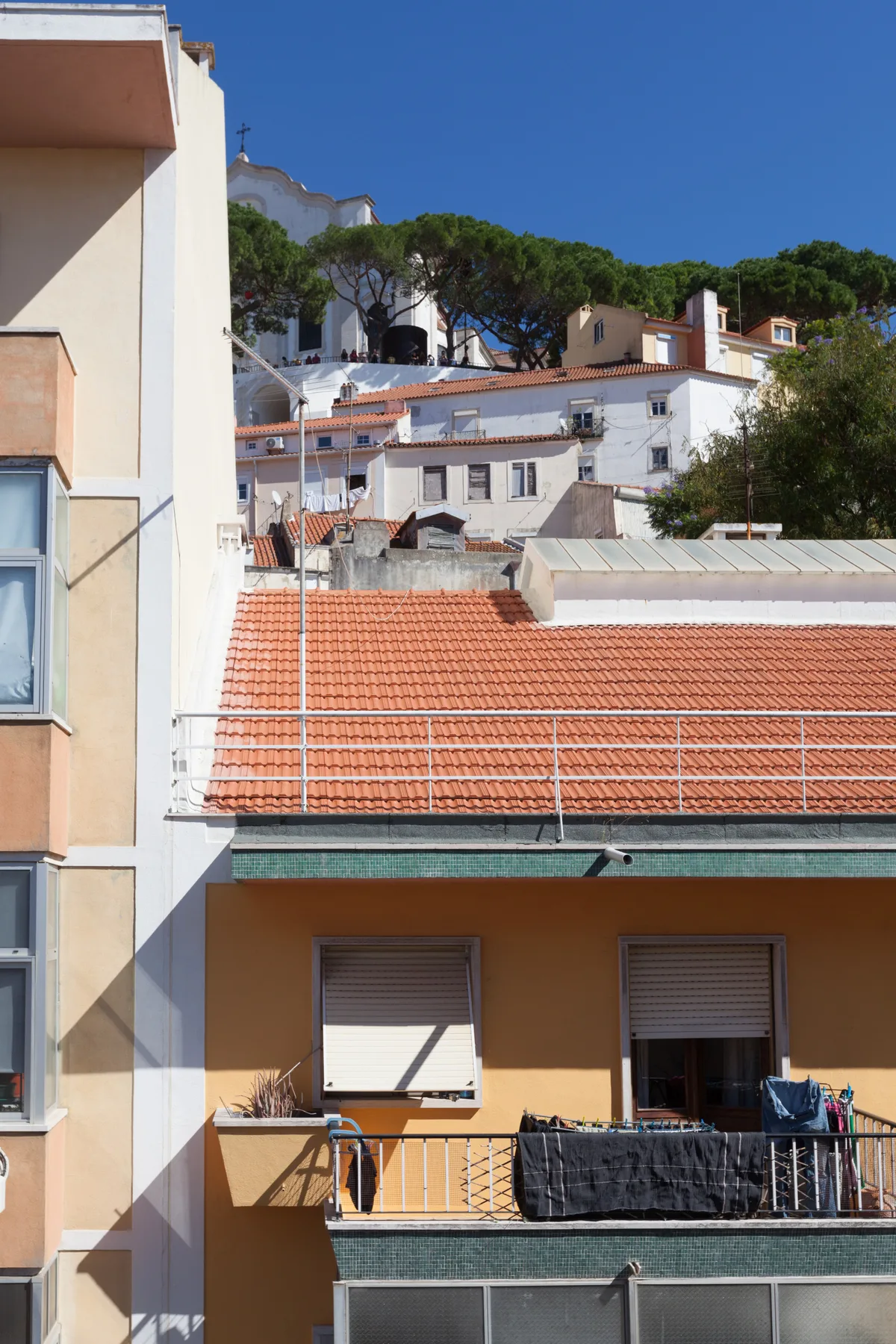 Una vista de ladera muestra casas cercanas con tejados de tejas y balcones.
