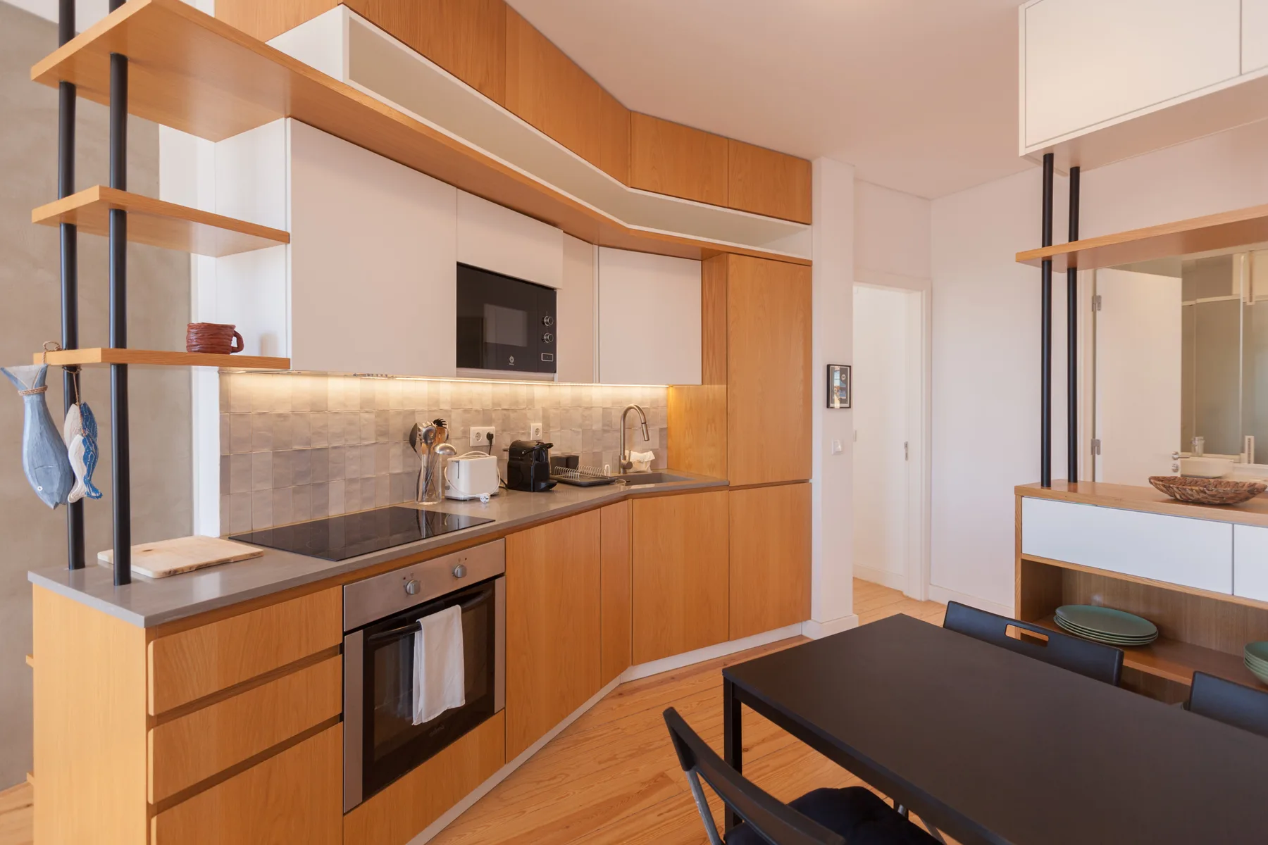 Una cocina moderna con armarios de madera y una mesa de comedor oscura.