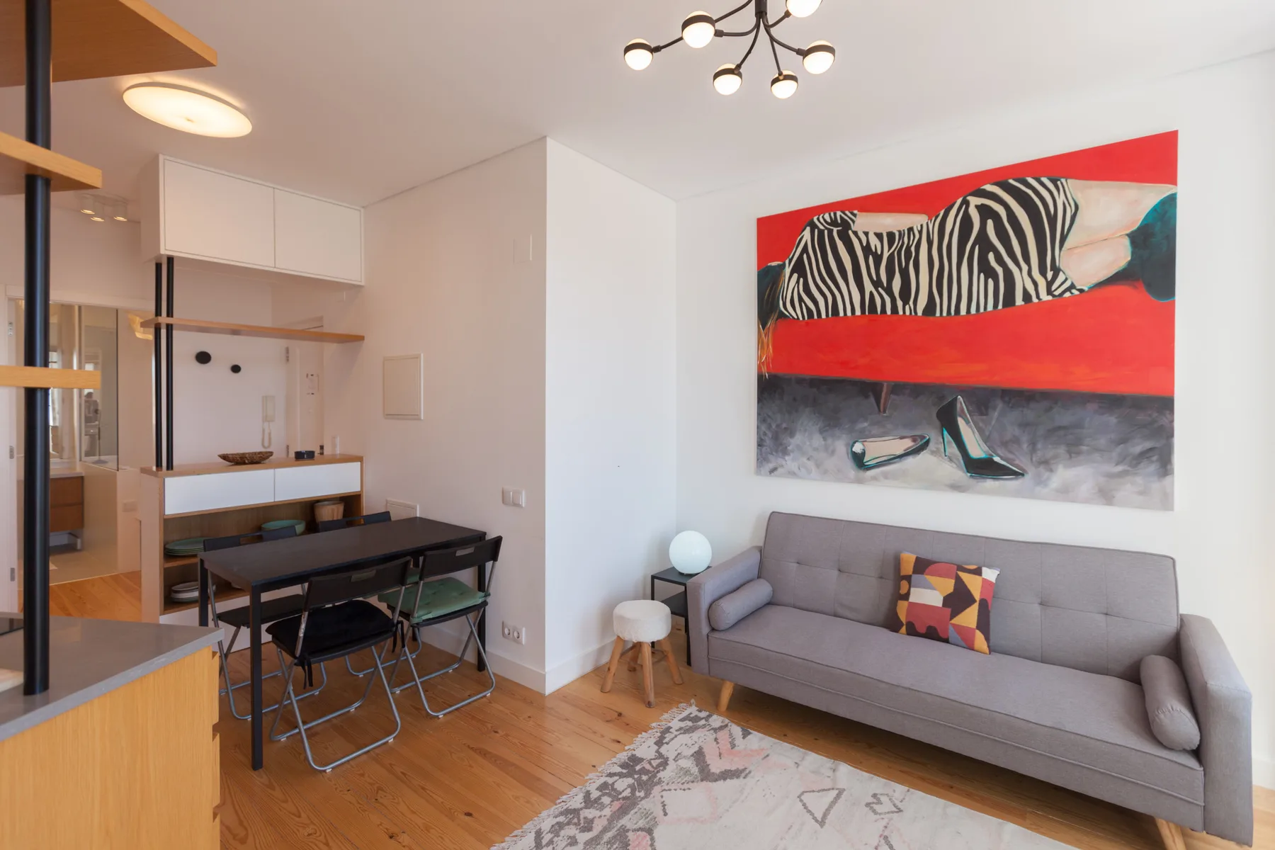 Una luminosa sala de estar y comedor con un sofá gris y una mesa de comedor.