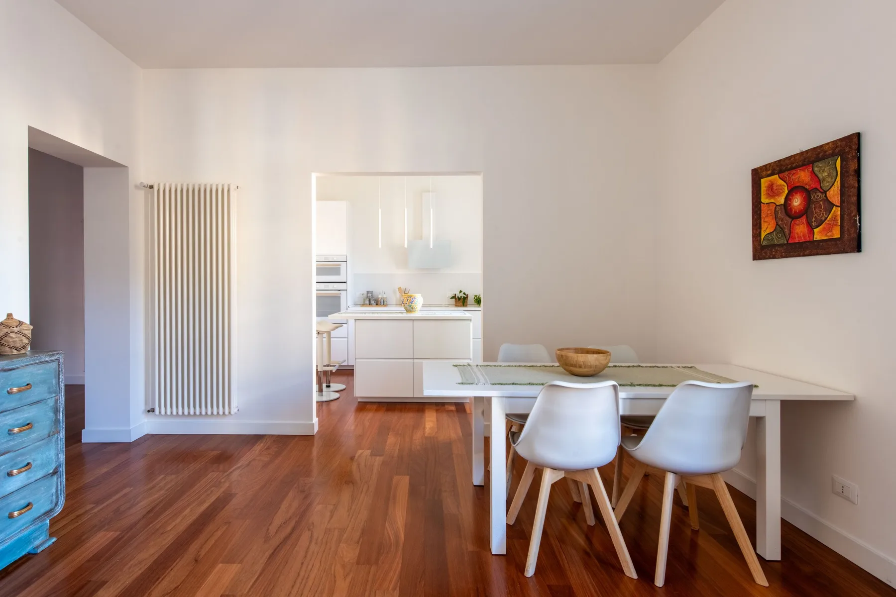 A dining area with a table and chairs beside an open kitchen.