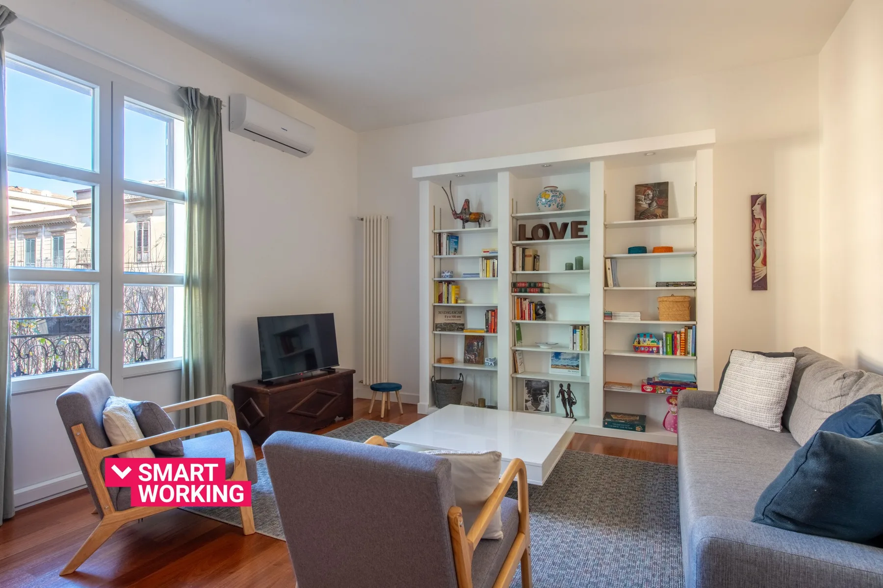 A bright living room with built-in bookshelves, seating, and a low coffee table.