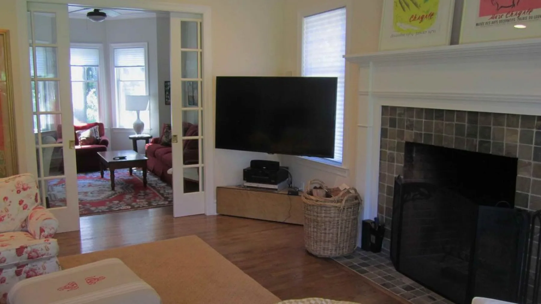 Una sala de estar con un televisor sobre una consola y una chimenea cerca.