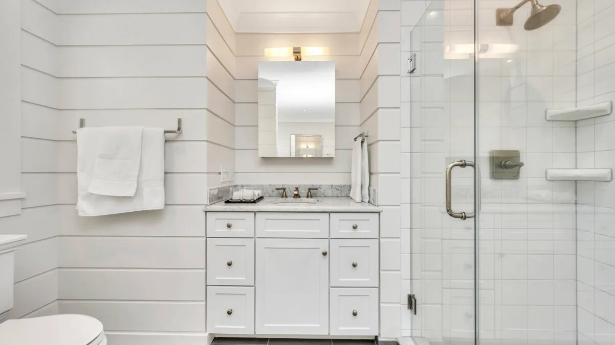Un baño luminoso con lavabo y ducha de vidrio.