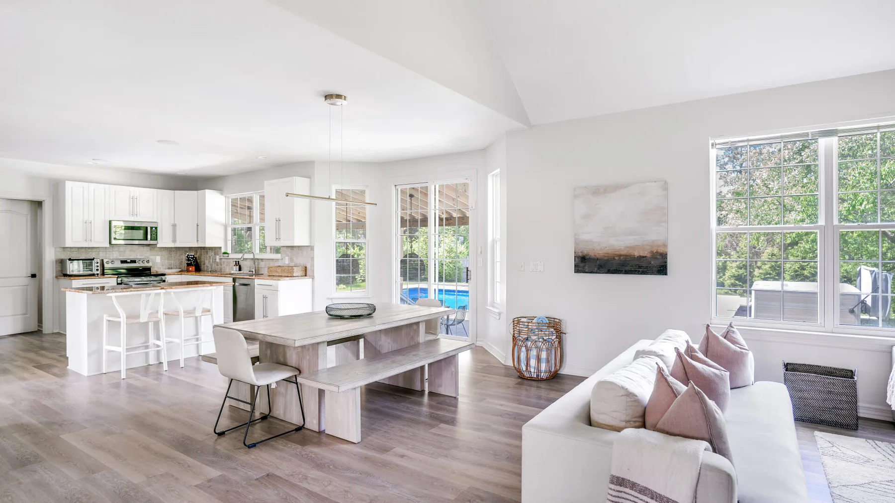 An open-plan kitchen and dining area opens onto a bright living space with large windows.