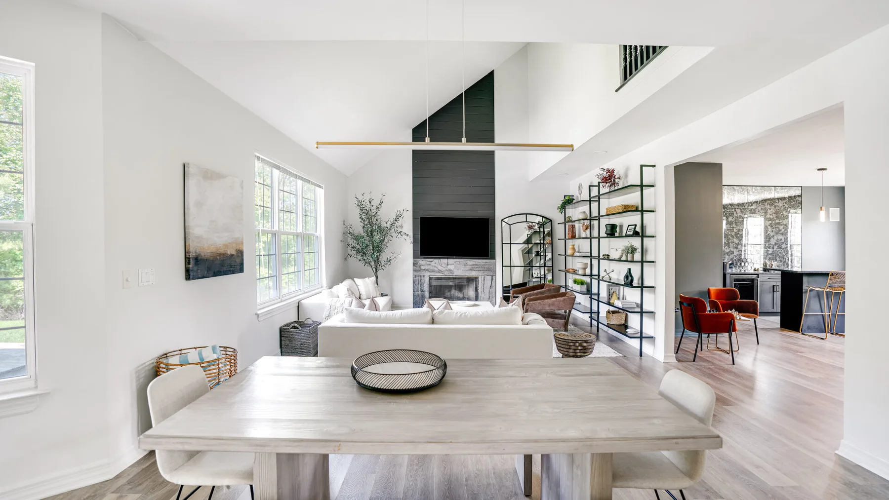 A bright open-plan living and dining room with a table facing the seating area.