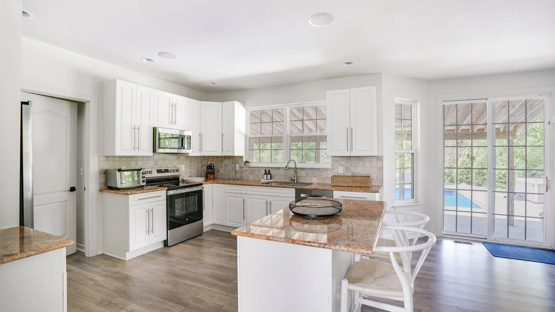 A bright kitchen with white cabinets and a central island.