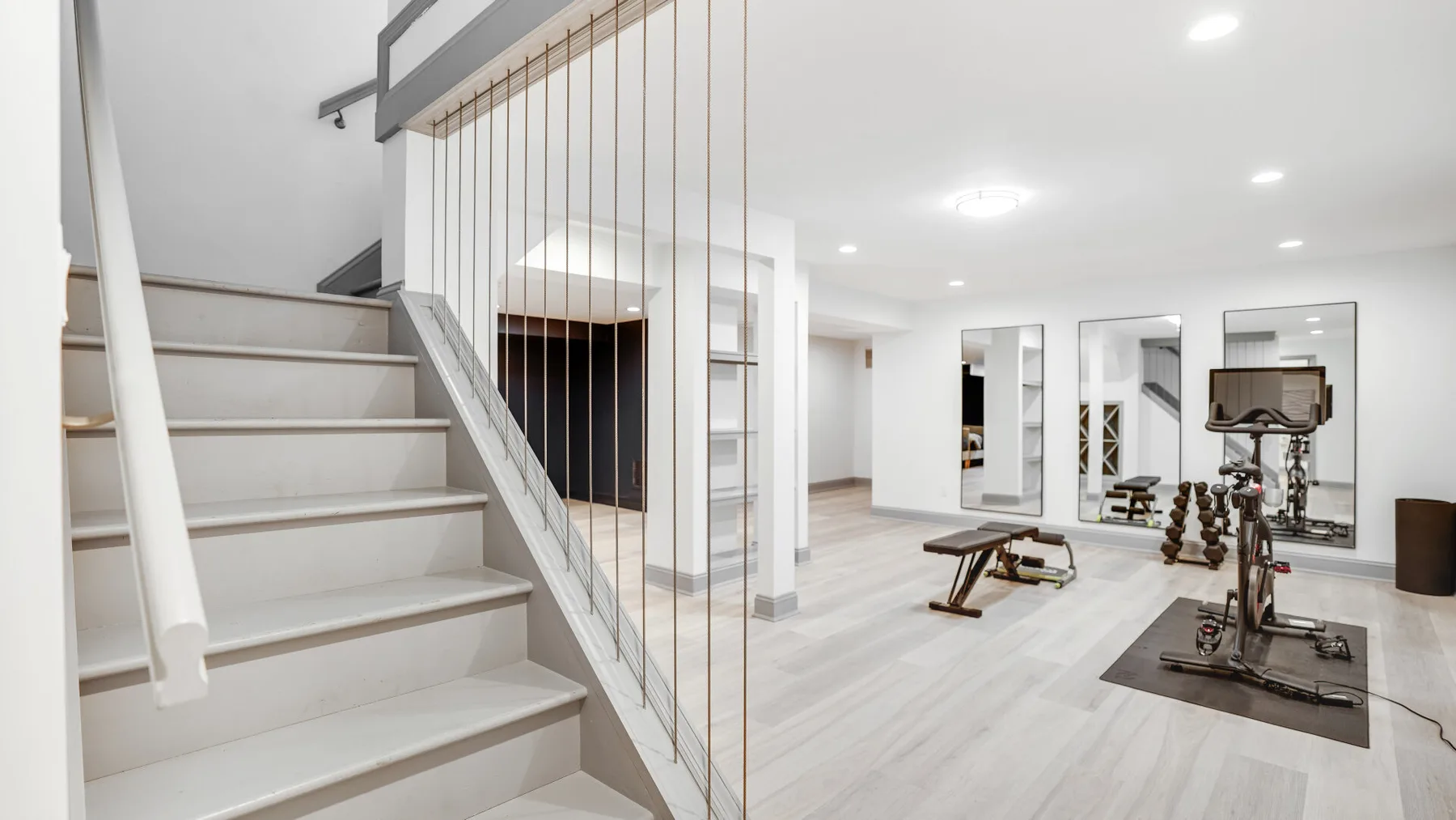A bright interior with a staircase and exercise equipment.